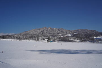 Fototapeta na wymiar Scenery of a rural village surrounded by mountains covered in white snow.