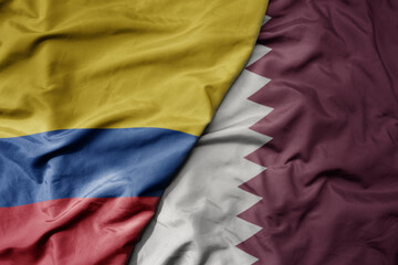 big waving national colorful flag of qatar and national flag of colombia .