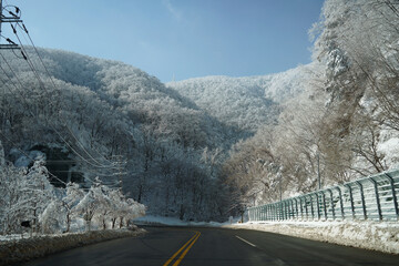 Winter mountain covered in snow next to the road where snow removal work was carried out