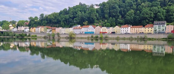 Fototapeta na wymiar Panoramic view of colorful row of reflected houses at river Danube, Passau, Bavaria, Germany