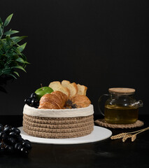 knitted jute basket with fruits and pastries on a dark background