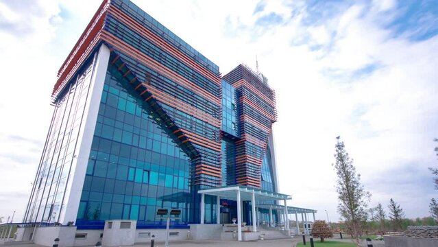 Modern Office Building Timelapse Hyperlapse in Aktobe City, Western Kazakhstan. Clouds Drift Overhead, Reflecting the Urban Sophistication of the Region
