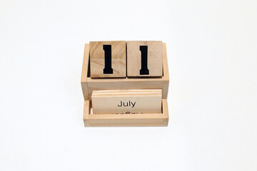 11th of July wooden perpetual calendar. Shot close up isolated on a white background