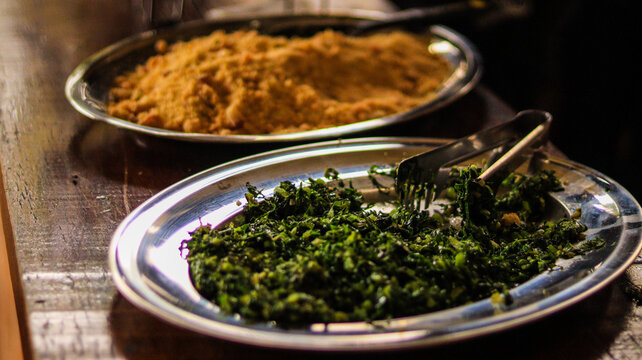 Complementos salada couve e farofa de uma comida brasileira feijoada