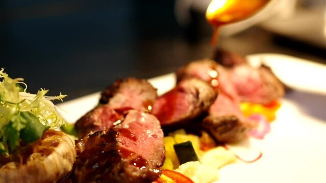 pouring sauce on sliced dry-aged steak red wine jus raw footage