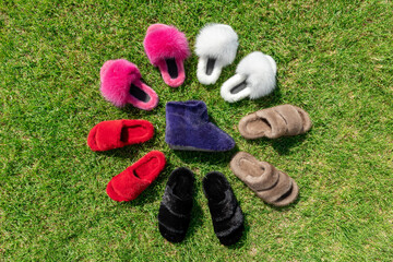 Beautiful fur footwear on a green grass. Flat lay.
