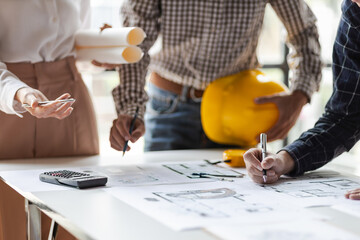 Group architects brainstorm together to discuss the design of a construction project map on...