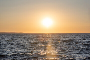 Fototapeta na wymiar Sunset against the backdrop of sea waves.