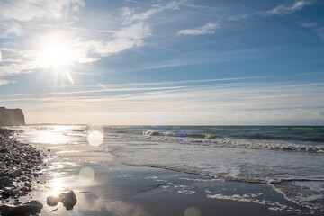 This photograph beautifully captures the early morning light as it spills over a serene beach. The...