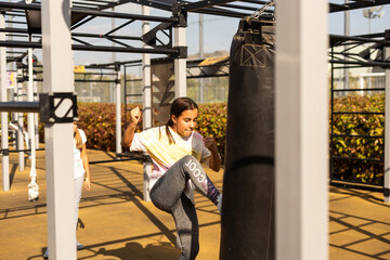 Young girl muay thai fighter working with the heavy bag