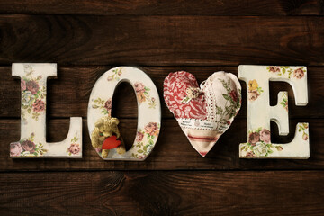 Wooden background with inscription created with diy letters LOVE and a heart in the place of V...