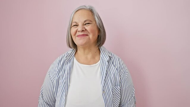 Crazy-fun grey-haired middle age woman making a mad, yet comical, fish face! confidently standing over isolated pink background, she's a hoot.
