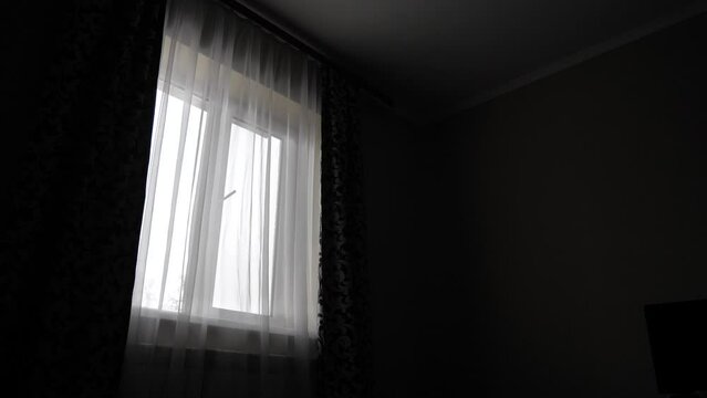 The man draws the dark curtains and does not allow light into the room,slow motion
