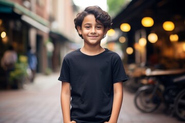 portrait of smiling boy in black t-shirt on city street