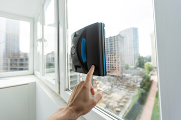 Vacuum cleaner robot cleaning window in high building outdoor.