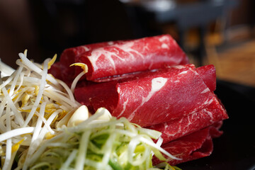 Raw red meat for shabu-shabu is thinly sliced and rolled into a round shape.