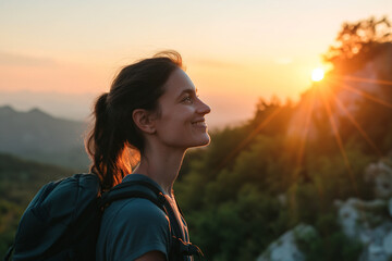 woman with an backpack standing in the mountain at sunset