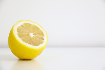 A half-sliced lemon isolated on white background, lemons are citrus fruits known for their sour...