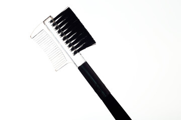 Close-up silhouette of a cosmetic eyebrow brush on a white background.