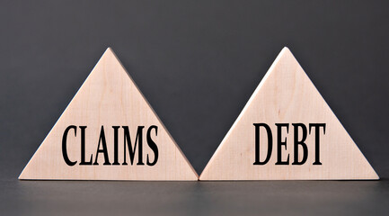 CLAIMS, DEBT - words on wooden triangles on dark background