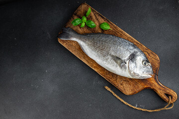 sea bream fish raw seafood tasty fresh healthy eating cooking appetizer meal food snack on the table copy space food background rustic keto or paleo diet Pescetarian