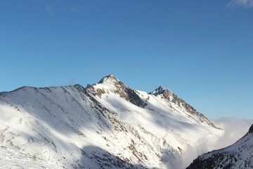 Fototapeta na wymiar Sunny mountains peaks in winter Alps.