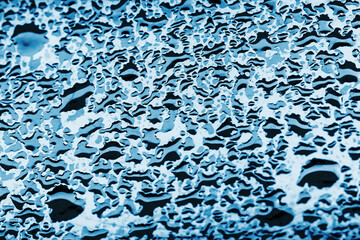 Water drops background. Wet glass surface texture. Winter window condensation problem. Bubble dew pattern. Transparent window blue raindrops. Humidity condensation texture. Blue color water.