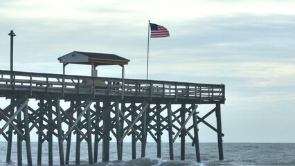 Fishing Pier with American Flag against morning sky
