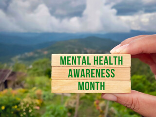 Health Awareness Concept - mental health awareness month text on wooden blocks with nature...