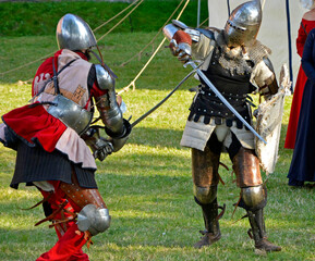 rekonstrukcja walk rycerzy na festynie, walka rycerzy, reenactment of knights' fights at the festival, people in knights' costumes fight during a historical reenactment at the Medieval Festival
