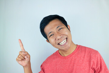 Asian man expression smiling while pointing to the side presenting the product. advertising concept