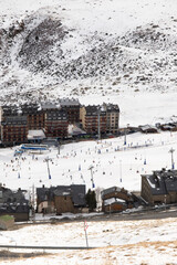Skiers in the white snow mountains between the city buildings. Extreme snow sports court for olympic athletes and professionals. Learning grounds for amateur sports and family.