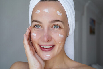 Morning skin care routine.  Young beautiful woman is  posing with a smears or a facial care brauty ...