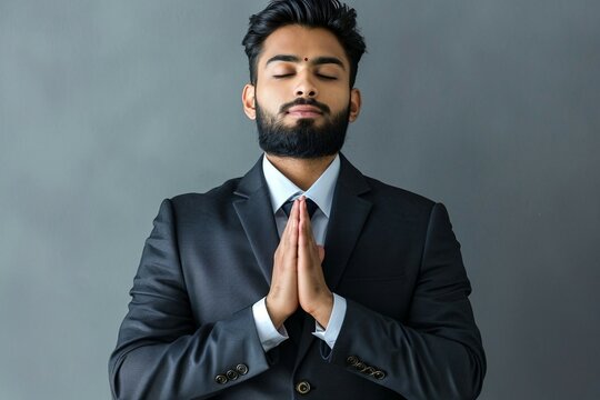 a man with his eyes closed and his hands together in prayer