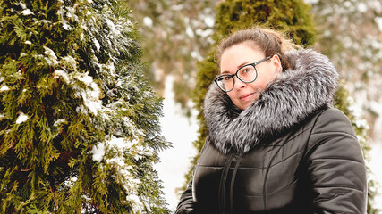 Portrait of a young woman with glasses in a park on a winter day. 1