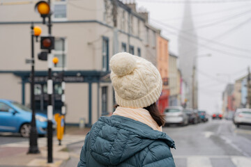 Closeup of woman walking with winter hat and enjoying a walk on her visit to a picturesque and...