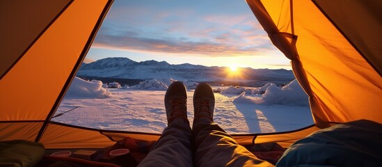 Closeup photo of feet in tent, sunset camping snow iceberg,orange blue light