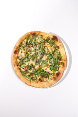 Italian pizza with cheese and mushrooms, garnished with arugula, top view on a white plate