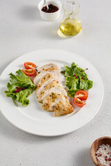 Grilled chicken breast with vibrant salad garnish on a minimalistic white setup, perfect for clean eating and diet concepts