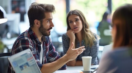 Male programmer discussing with female colleague at tech start-up office.