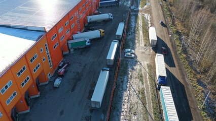 Unloading-loading of goods into trucks near a large logistics center, warehouse. Trucks loaded with...