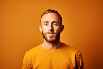 Obraz premium Portrait of a young man looking at camera over orange background