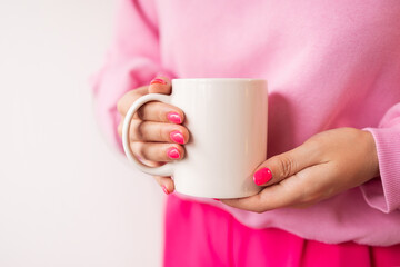 Female hands holding white mug mockup for sublimation presentation design. Pink manicure, pink sweatshirt, trendy color. stock photos of white coffee mug in female hands for designers