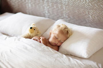 Fototapeta na wymiar Baby boy sleeping in white bed