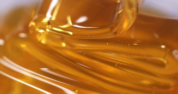 Super slow motion macro of bio organic golden sticky liquid honey is flowing and dripping at 1000 fps.