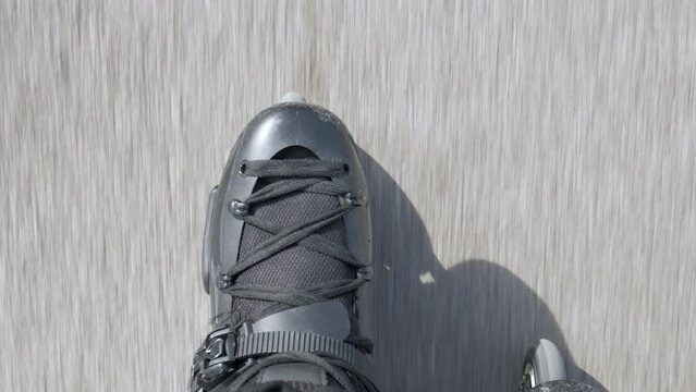 The inline skate boots of a person rollerblading down the street. High angle view, personal perspective, close up shot