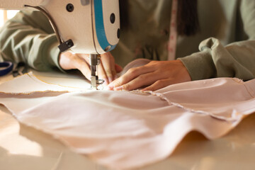 Handmade women use modern sewing machines to sew clothes at work. The process of manually sewing...