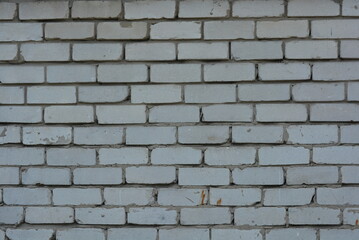 Unusual construction background, white bricks smeared with gray cement, not professional and uneven. The Soviet wall is made of light, white brick.