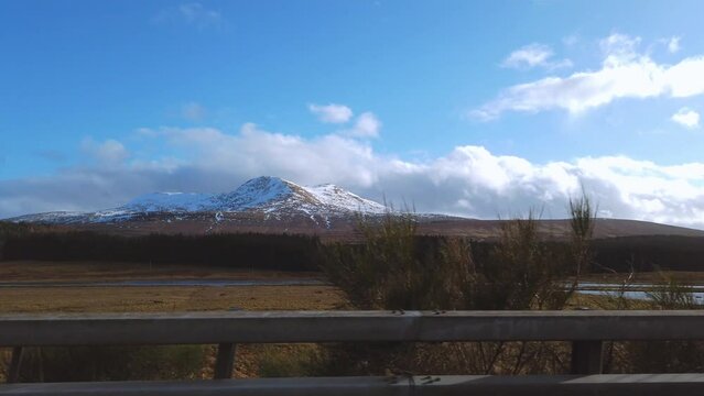 Car point of view, POV driving along a landscape and scenery through beautiful roads in the Scottish highland.