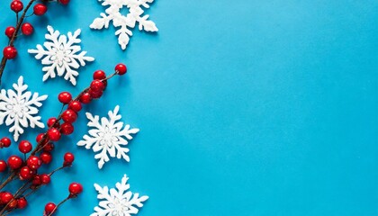 christmas or winter composition snowflakes and red berries on blue background christmas winter new year concept flat lay top view copy space